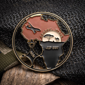 Circular cutout challenge coin featuring the continent of Africa, an aircraft silhouette, camel, and acacia tree with text Agadez Niger AB 201.