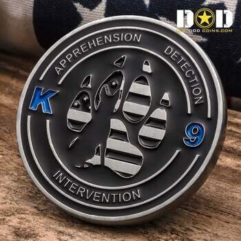 Circular challenge coin featuring a paw print with flag patterns and the words Apprehension, Detection, and Intervention.
