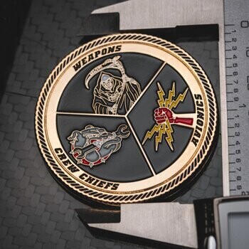 Circular challenge coin featuring a grim reaper, a bulldog with a wrench, and a fist holding lightning bolts on a black background with gold rope edging.