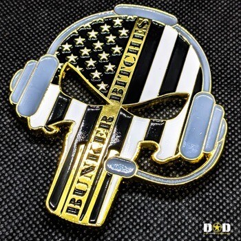 Skull-shaped challenge coin with headphones, American flag pattern, and 'Bunker Bitches' text in gold and enamel.