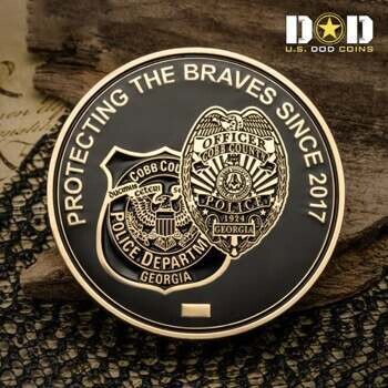 Gold and black challenge coin featuring Cobb County Georgia Police Department badges and the text Protecting the Braves Since 2017.