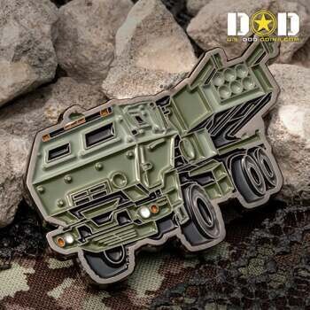 Custom shaped challenge coin in the design of a green M142 HIMARS rocket launcher vehicle with detailed enamel work.