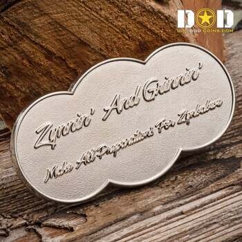 Oval shaped silver challenge coin with 'Zippin' And Grinnin'' text in script font against a textured background.