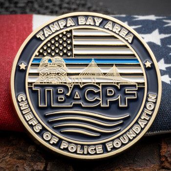 Gold and blue challenge coin for Tampa Bay Area Chiefs of Police Foundation featuring a bridge, American flag, and thin blue line.