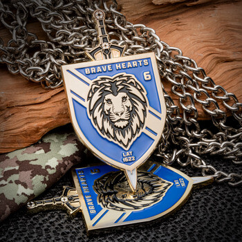 Shield-shaped challenge coin featuring a lion head and sword, blue and gold enamel with Brave Hearts text.