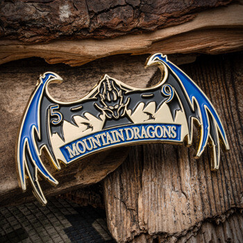 A custom coin shaped like dragon wings featuring blue and black enamel with the text Mountain Dragons and the number 59.