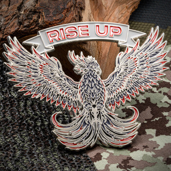 Rise Up phoenix coin with silver plating, white enamel banner, and red and black accents on outstretched wings.