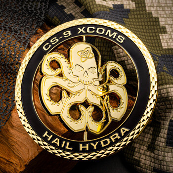Gold CS-9 XCOMS Hail Hydra challenge coin with a skull octopus emblem on camouflage background