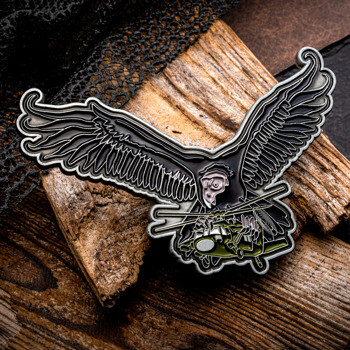 Custom lapel pin shaped like a vulture with spread wings carrying a military helicopter in its talons.