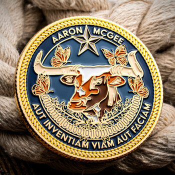 Custom challenge coin featuring a longhorn steer skull, butterflies, binary code, and a rope border design.