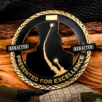Gold and black cutout challenge coin reading Presented for Excellence with missile silhouette graphics and diamond cut edge