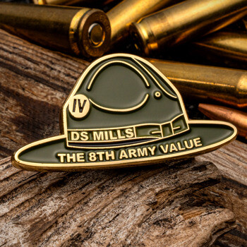 Campaign hat shaped lapel pin with olive green enamel and gold trim featuring text for DS Mills and The 8th Army Value.