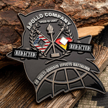 Matte black custom challenge coin for Apollo Company 2D Multi-Domain Effects Battalion featuring a torch, flags, and globe design.