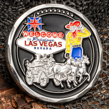 Round challenge coin featuring the Las Vegas sign, a colorful cowboy character, and a silver horse-drawn carriage on a black background.