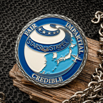 Circular Stars and Stripes challenge coin featuring a globe map of Japan and Asia in blue and white enamel with a silver diamond-cut edge.