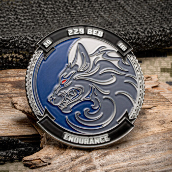 Round challenge coin featuring a stylized wolf head with red eyes on a blue background, inscribed with 229 BEB and Endurance.