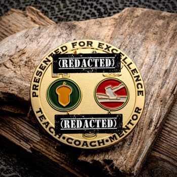 Gold-plated challenge coin featuring an acorn and ax insignia with the text Presented for Excellence, Teach, Coach, Mentor.
