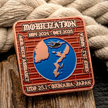 Square copper challenge coin featuring a map of Japan and a helicopter over a blue circle, set against a brick pattern background.
