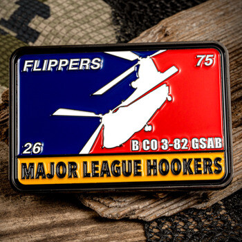 Rectangular challenge coin with a helicopter silhouette, red and blue background, and 'Major League Hookers' text.