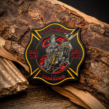 Las Vegas Fire and Rescue challenge coin featuring a skeleton riding a dark horse within a maltese cross, resting on tree bark.