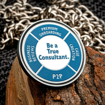 Circular blue and white challenge coin featuring the text Be a True Consultant and P2P, displayed on a piece of wood with a chain background.