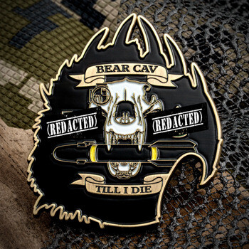 Shield-shaped lapel pin featuring a white bear skull biting a projectile on a black and gold background with the text Bear Cav.