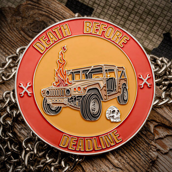 Circular challenge coin featuring a burning military vehicle, a skull, and crossed wrenches with the text Death Before Deadline.