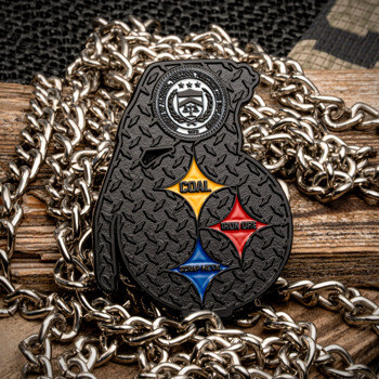 Grenade-shaped challenge coin with textured black finish, featuring three colored diamond emblems labeled Coal, Iron Ore, and Scrap Metal.