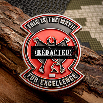 Shield-shaped challenge coin featuring a red background, a black winged creature, and text reading This is the Way and For Excellence.