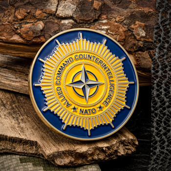 Allied Command Counterintelligence NATO challenge coin with blue and yellow enamel sunburst design and compass star.