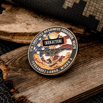 Round challenge coin for the 5th Logistics Readiness Squadron featuring a stealth bomber over an American flag and clouds.