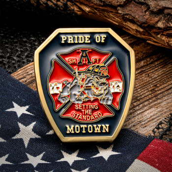 Shield-shaped challenge coin featuring a bulldog in a firefighter helmet, Maltese cross, and the text Pride of Motown A Shift.