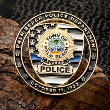 Palm Beach Police Department challenge coin with thin blue line flag and town seal on a wood background.