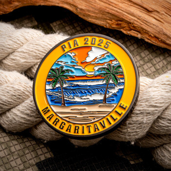 PIA 2025 Margaritaville challenge coin featuring a tropical beach sunset with palm trees and waves, resting on a white rope.