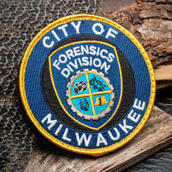 Circular embroidered patch for City of Milwaukee Forensics Division featuring a blue shield, gear, and forensic symbols with a yellow border.