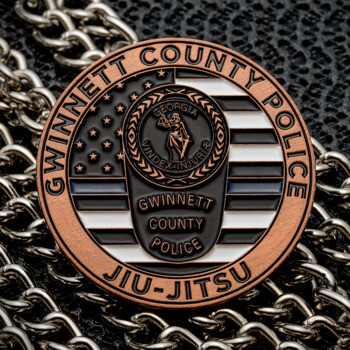 Gwinnett County Police Jiu-Jitsu challenge coin featuring a thin blue line American flag design and Georgia state seal over a background of silver chains.