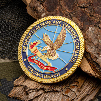 Gold-rimmed challenge coin for Information Warfare Training Command Virginia Beach featuring an eagle with a torch over a light blue globe background.