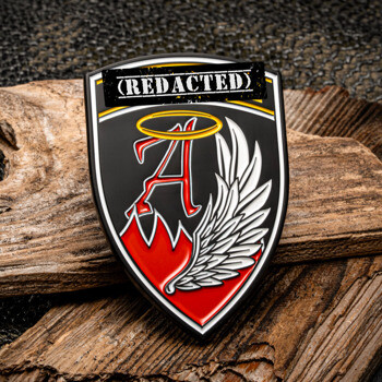 Shield-shaped lapel pin featuring a red letter A with a gold halo and a white wing design on a black background.