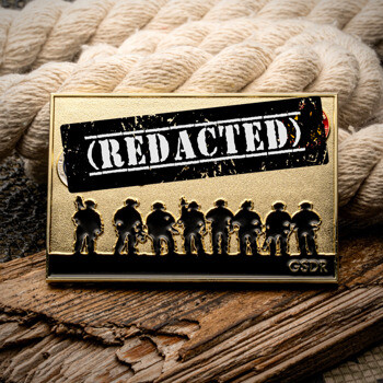 Rectangular gold challenge coin featuring black tactical team silhouettes and a redacted stamp design, displayed on wood and rope.