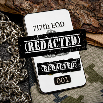 Rectangular 717th EOD challenge coin with white enamel, silver numbering, and redacted text details on a camouflage and wood background.