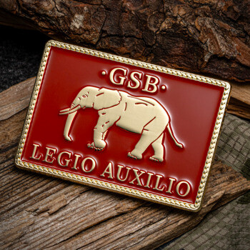Rectangular challenge coin with a gold elephant emblem on a red background featuring GSB Legio Auxilio text and rope border.
