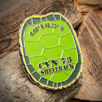Turtle shell shaped challenge coin with green enamel, featuring CVN 73 Shellback text and coordinates.