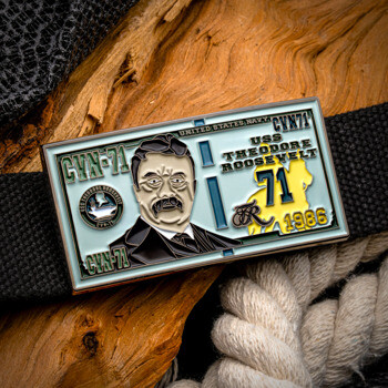 Rectangular belt buckle featuring Theodore Roosevelt portrait, CVN 71 markings, and United States Navy text on a light blue enamel background.
