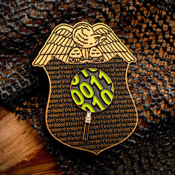 Gold eagle shield lapel pin featuring a binary code background and a magnifying glass highlighting green digits.