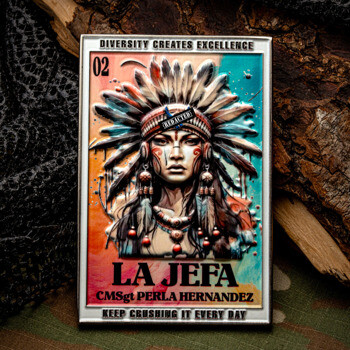Rectangular challenge coin featuring a colorful illustration of a woman in a traditional feathered headdress with the text La Jefa CMSgt Perla Hernandez.