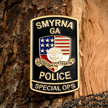 Rectangular challenge coin for Smyrna GA Police Special Ops featuring a shield with American flag elements and gold text on a black background.