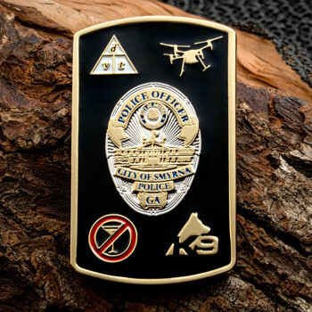 Rectangular black challenge coin with gold City of Smyrna Police badge, drone icon, K9 symbol, and no-alcohol sign.