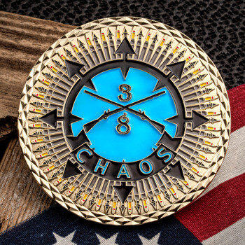 Gold challenge coin with 3/8 Chaos text, crossed rifles on a blue background, and a diamond cut edge.