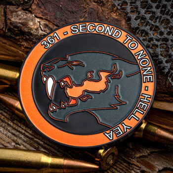 Custom circular challenge coin with an orange and black panther head emblem, surrounded by bullets on a rustic wooden surface.