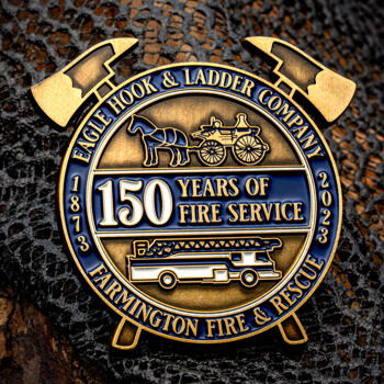 Eagle Hook and Ladder Company lapel pin featuring crossed fire axes, a vintage horse-drawn carriage, a modern fire truck, and blue enamel details.